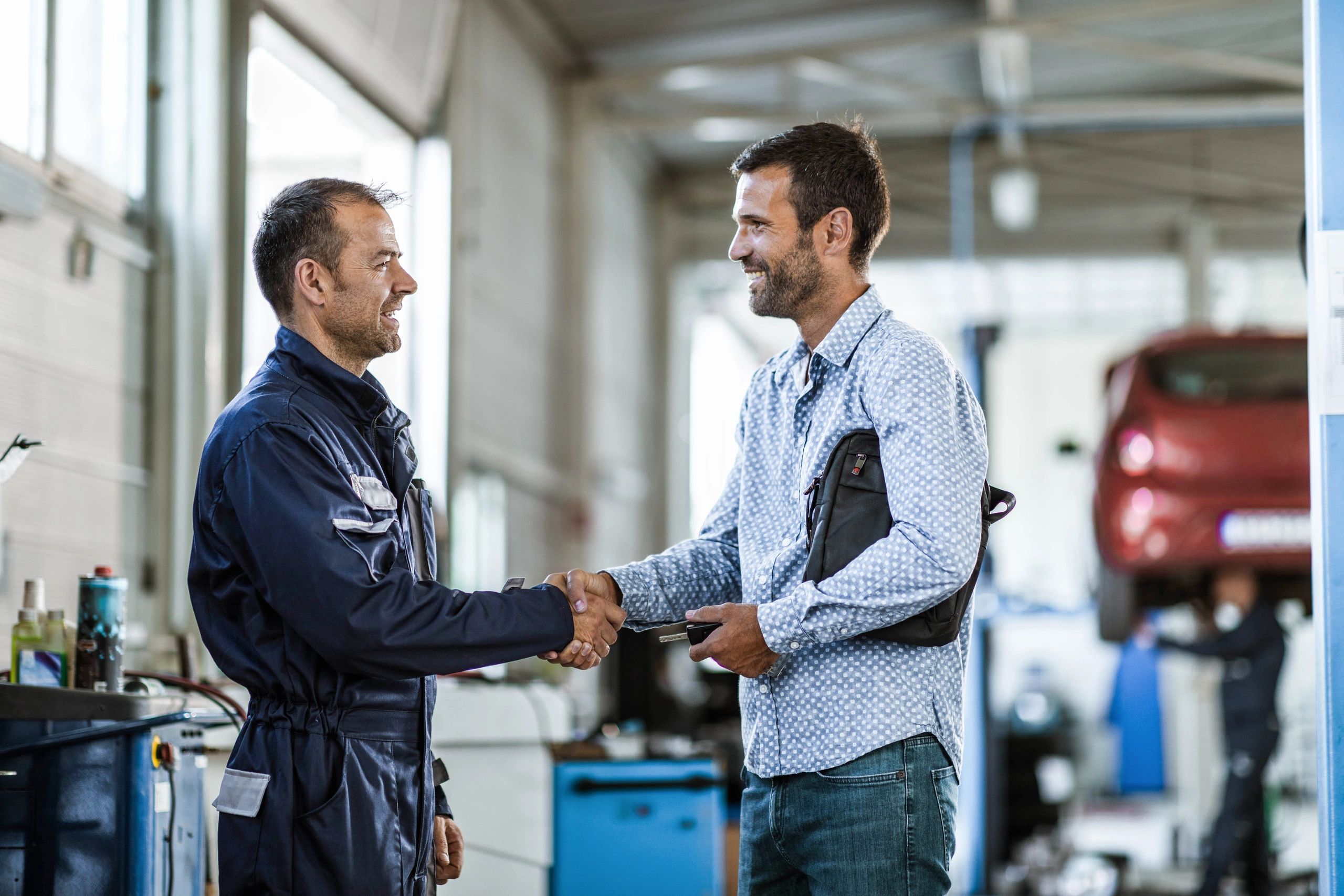 Mechanic shaking hands with a customer in an auto repair shop