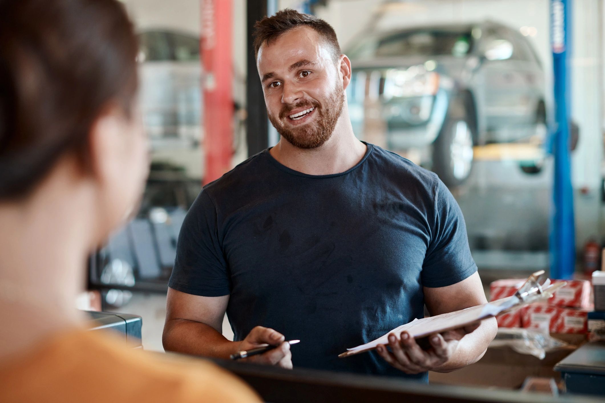 Customer speaking with a mechanic in an auto repair shop