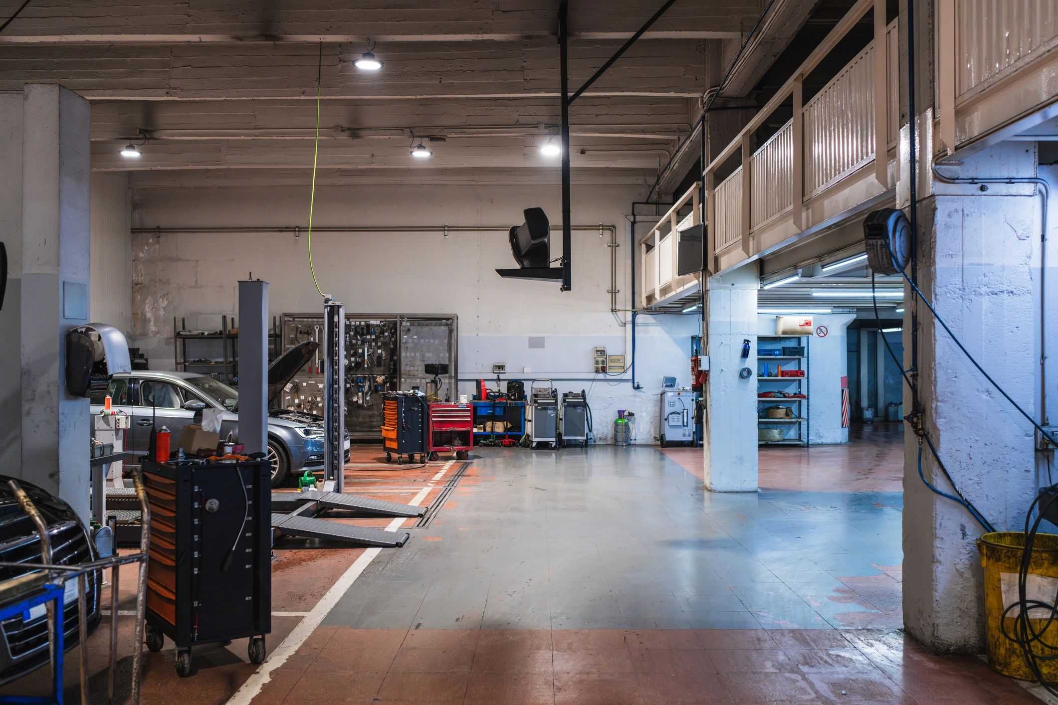 Car repair shop service bay with lifts and toolboxes